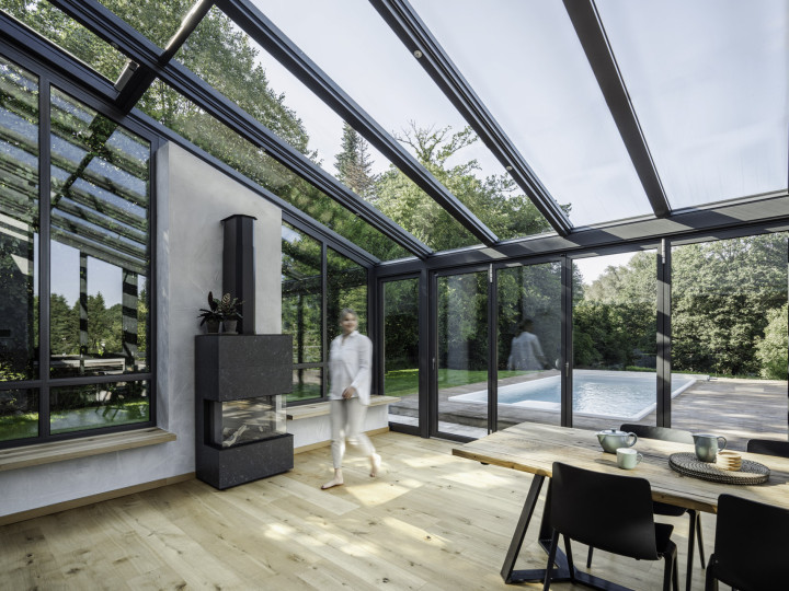 Ein förderfähiger Wintergarten von Solarlux lässt sich mit einer ebenfalls förderfähigen Glas-Faltwand kombinieren – für viel Licht, großzügige Glasflächen und weit geöffnete Übergänge zur Terrasse. Mit einem Handgriff öffnet sie die gesamt